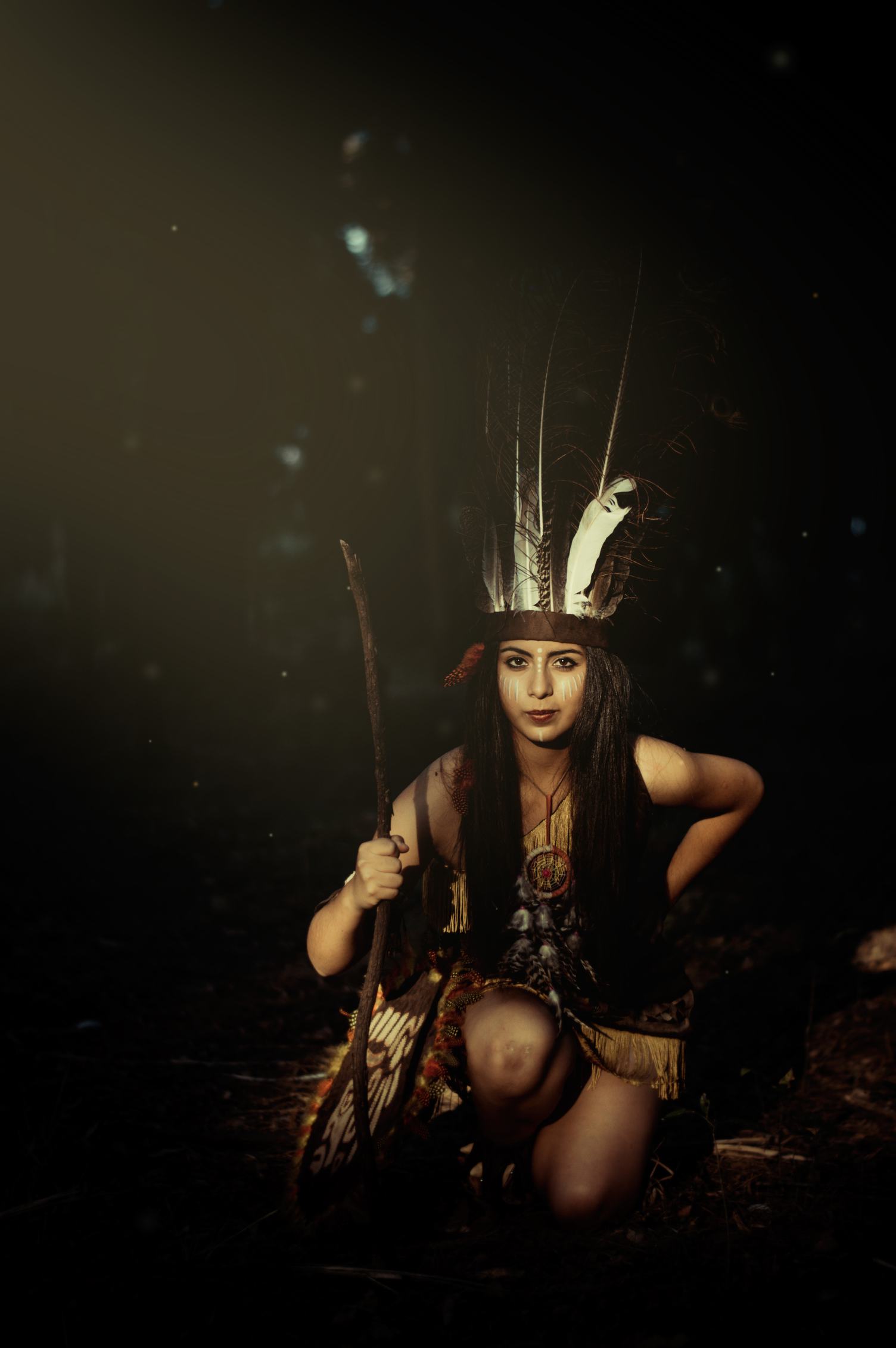 Native American Woman Wearing Plume Holding a Stick