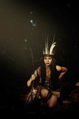 Native American Woman Wearing Plume Holding a Stick