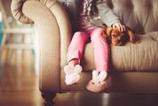 Small Girl Sitting with her Dog on a Sofa
