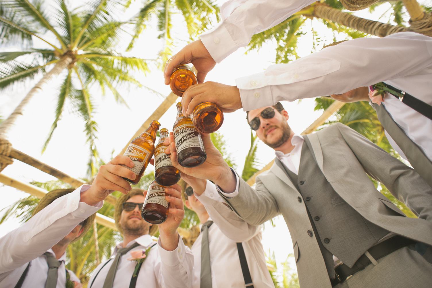 Men Drinking Beer under the Palmtrees During the Wedding Party