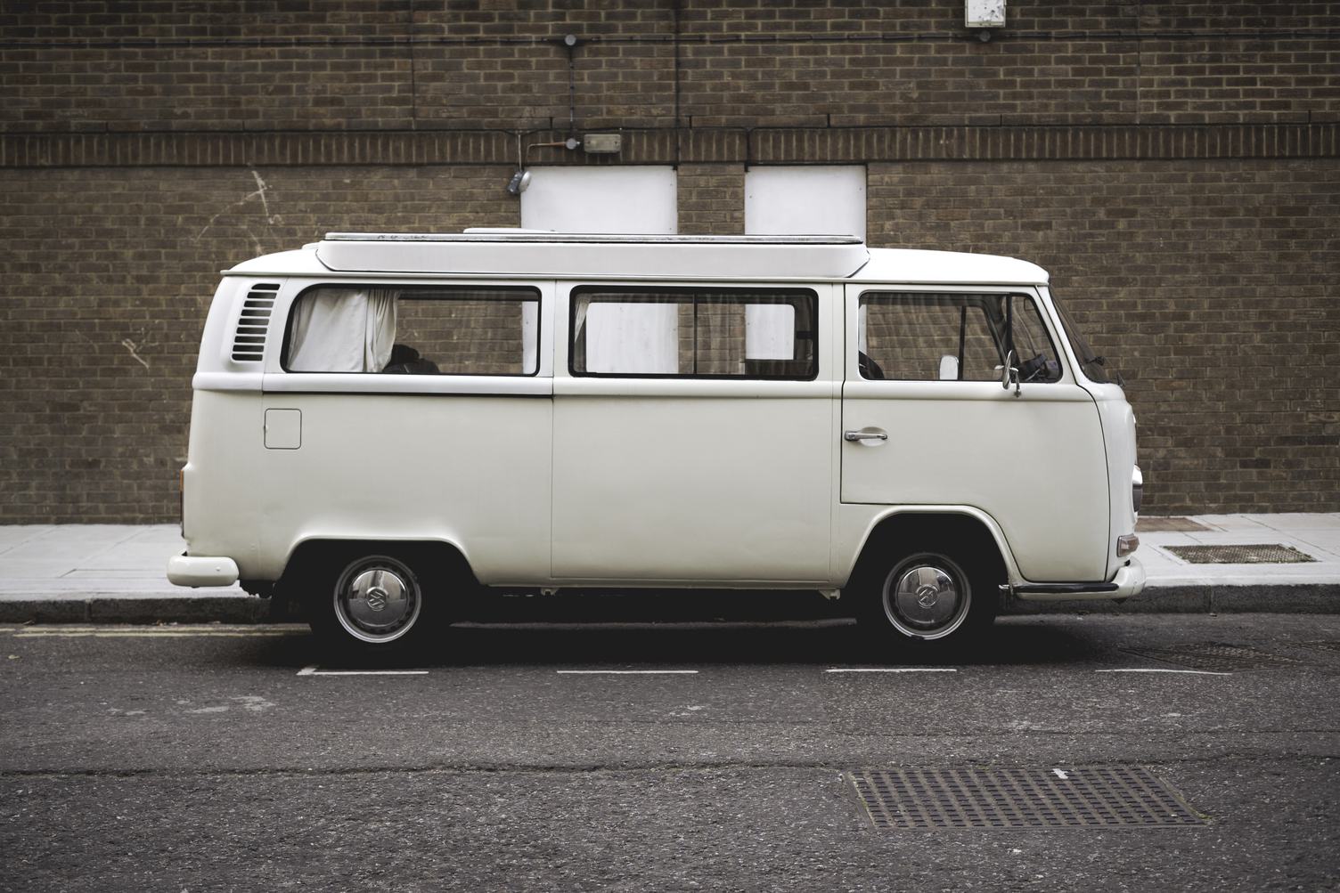Free Photo: A White Volkswagen Minibus Parked in Front of Brick Wall