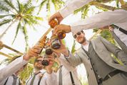 Men Drinking Beer under the Palmtrees During the Wedding Party