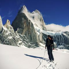 Man Standing in front of Snow Covered Mountain Peak
