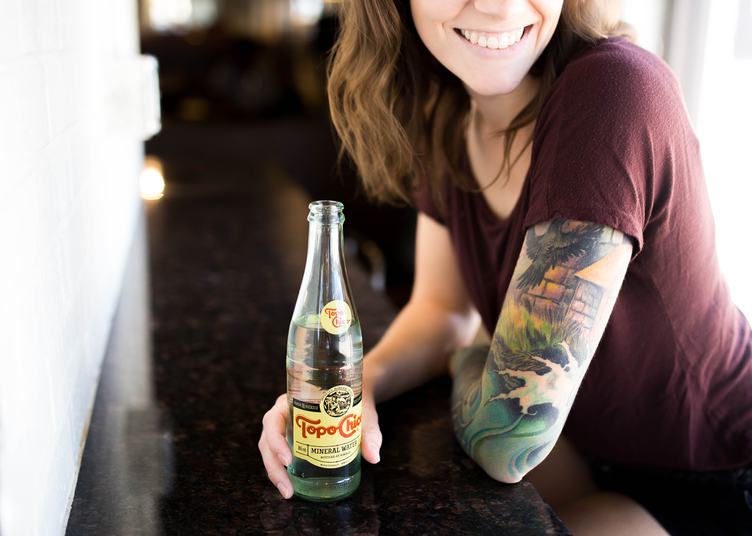 Young Woman with Tattoo Drinking Mineral Water