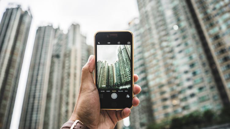 Taking a Photo of Skyscrapers one Hand Holding Smartphone