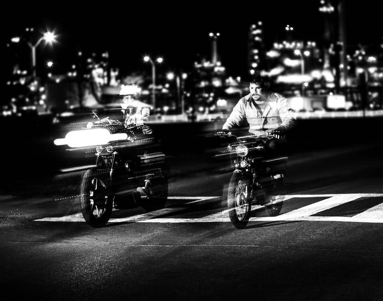 Motion of Two Bikers Racing on the Street at Night