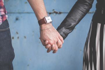 Couple Holding Hands against a Grungy Blue Wall