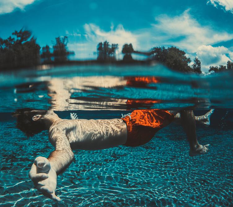 Boy Floating Underwater in a Lake