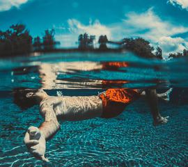 Boy Floating Underwater in a Lake