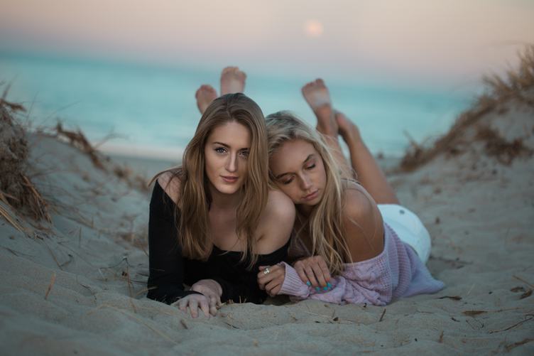 Two Happy Girls Lying on a Dune