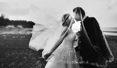 Bride and Groom Kissing under the Veil