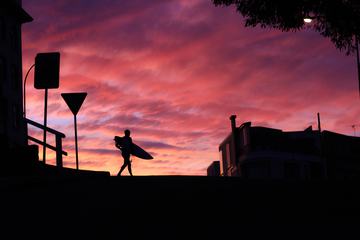 Silhouette of a Surfer against a Sunset Sky