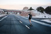 Blond Girl Skating on an Asphalt Road
