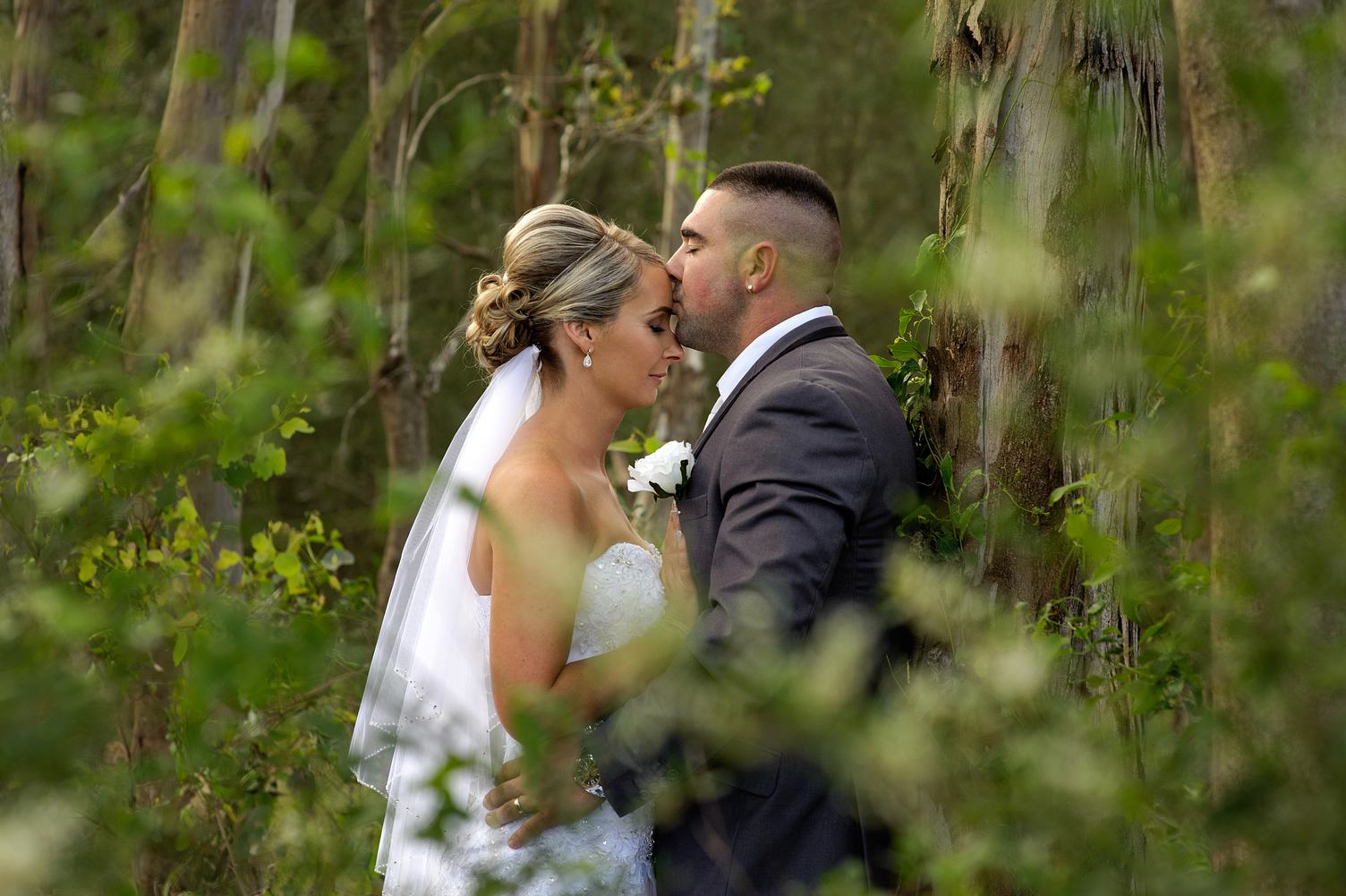 Bride and Groom Kissing in the Forest