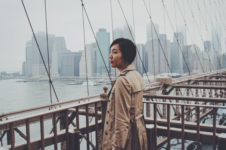 Woman wearing a Trench Coat standing on Brooklyn Bridge, New York