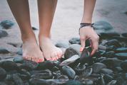 Barefoot Woman Standing on the Sea Pebbles