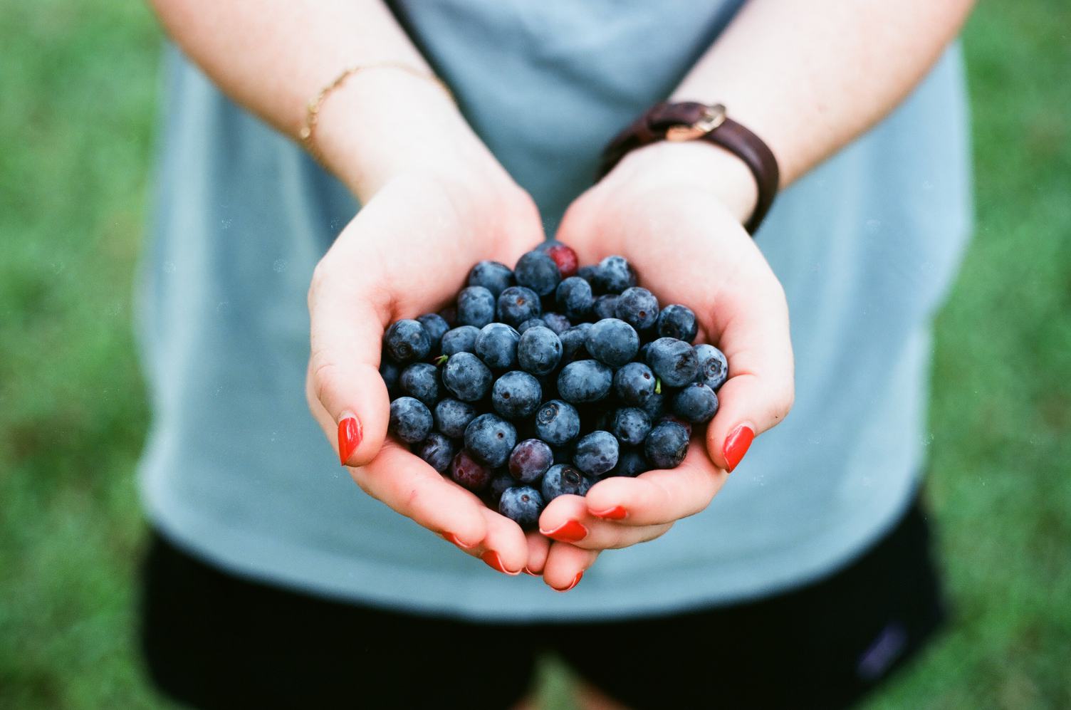 Woman with Handful of Fresh Blueberries