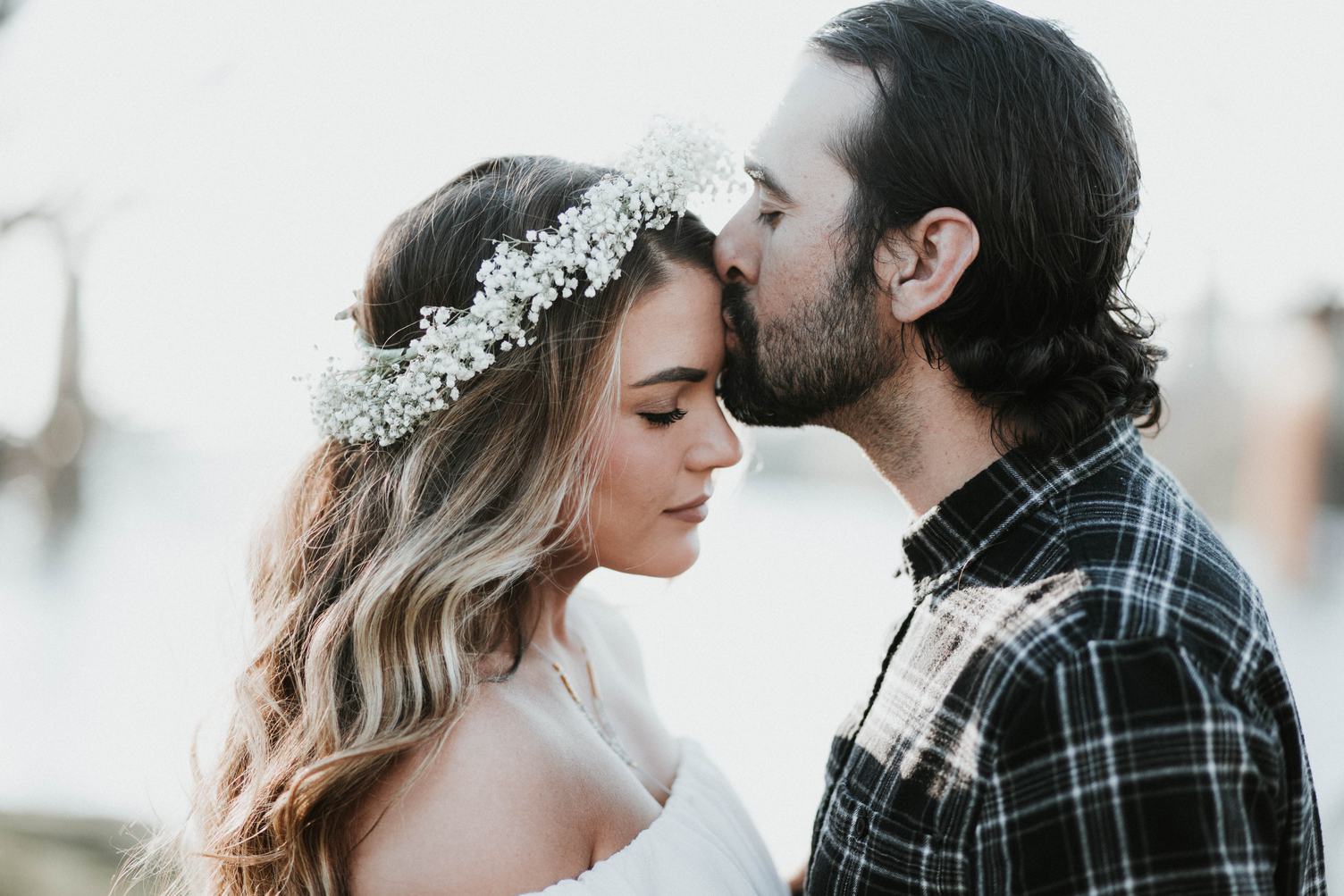Beard Man Kisses in Forehead Beautiful Woman with Floral Wreath