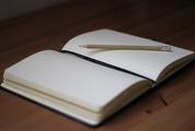 Blank Notebook with Pencil on Desk Background