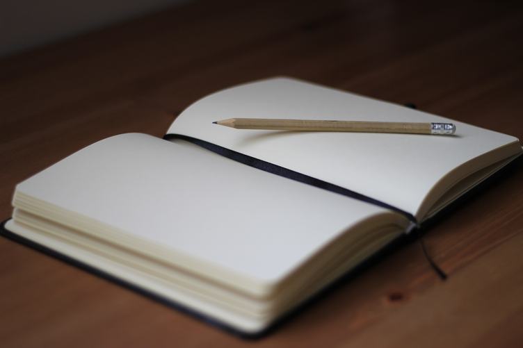 Blank Notebook with Pencil on Desk Background