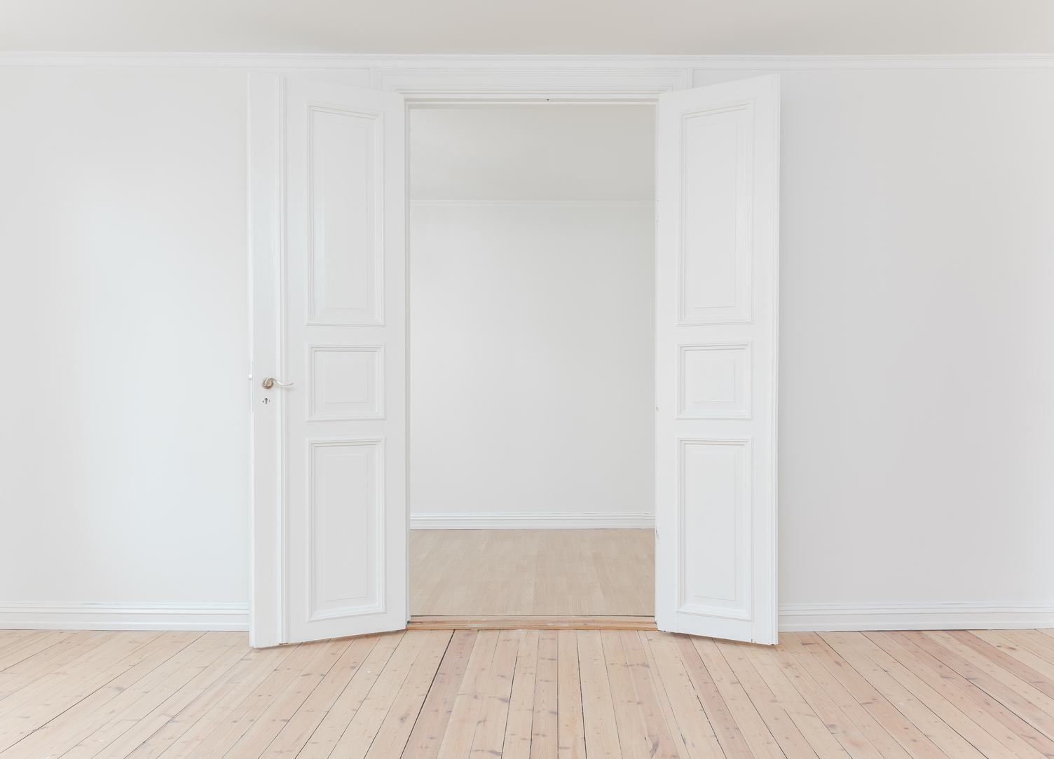 White Door in Empty Apartment Room with Wooden Floor