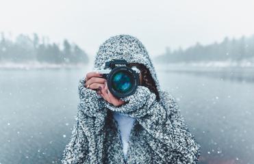 Woman Holding Nikon Camera Photographing Outdoors in Winter