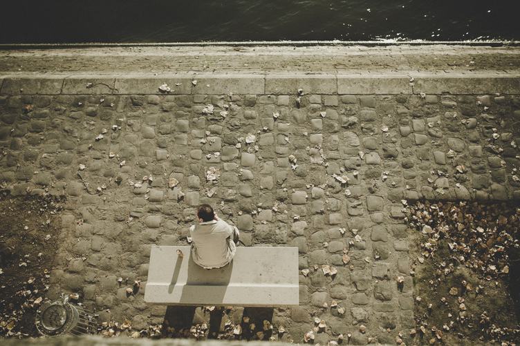 Man Sitting on a Bench at the River Bank of Seine