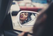 Woman Applying Lipstick in a Car, Mirror Reflection