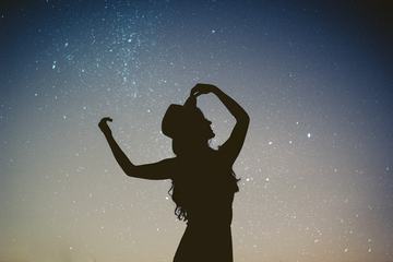 Silhouette of a Woman Standing Outside, Starry Night Background