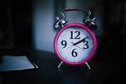 Pink Alarm Clock on Dark Background