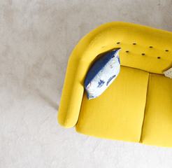 Yellow Sofa with Pillow on Beige Carpet Background