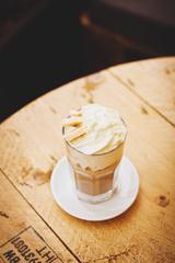 Coffee with Cream and Bananas on Wooden Table