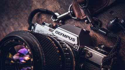 Old SLR Olympus Camera on Wooden Background