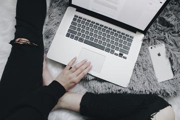 Girl Sitting on the Fluffy Rug Blogging on her MacBook