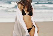 Beautiful Young Woman in Black Bikini Posing on the Beach