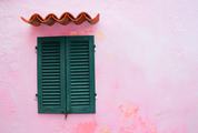 Closed Green Window Shutters on Grunge Pink Wall Background