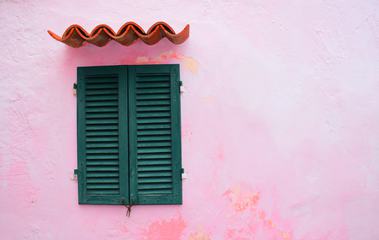 Closed Green Window Shutters on Grunge Pink Wall Background