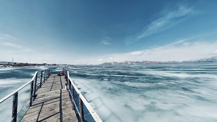 Scenery with a Pier in a Frozen Lake