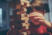 Boy is Playing Jenga, a Wood Blocks Tower Game