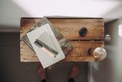 Top View of Notebook with Pen and Light Bulb on Wooden Table