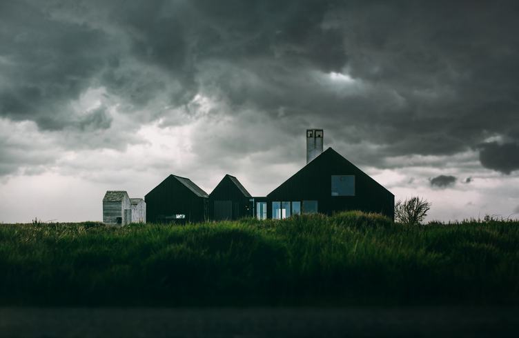 Modern House on the Green Land and Dramatic Clouds