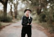 Fashion Blonde Woman Posing Outdoor in Black Hat and Leather Jacket
