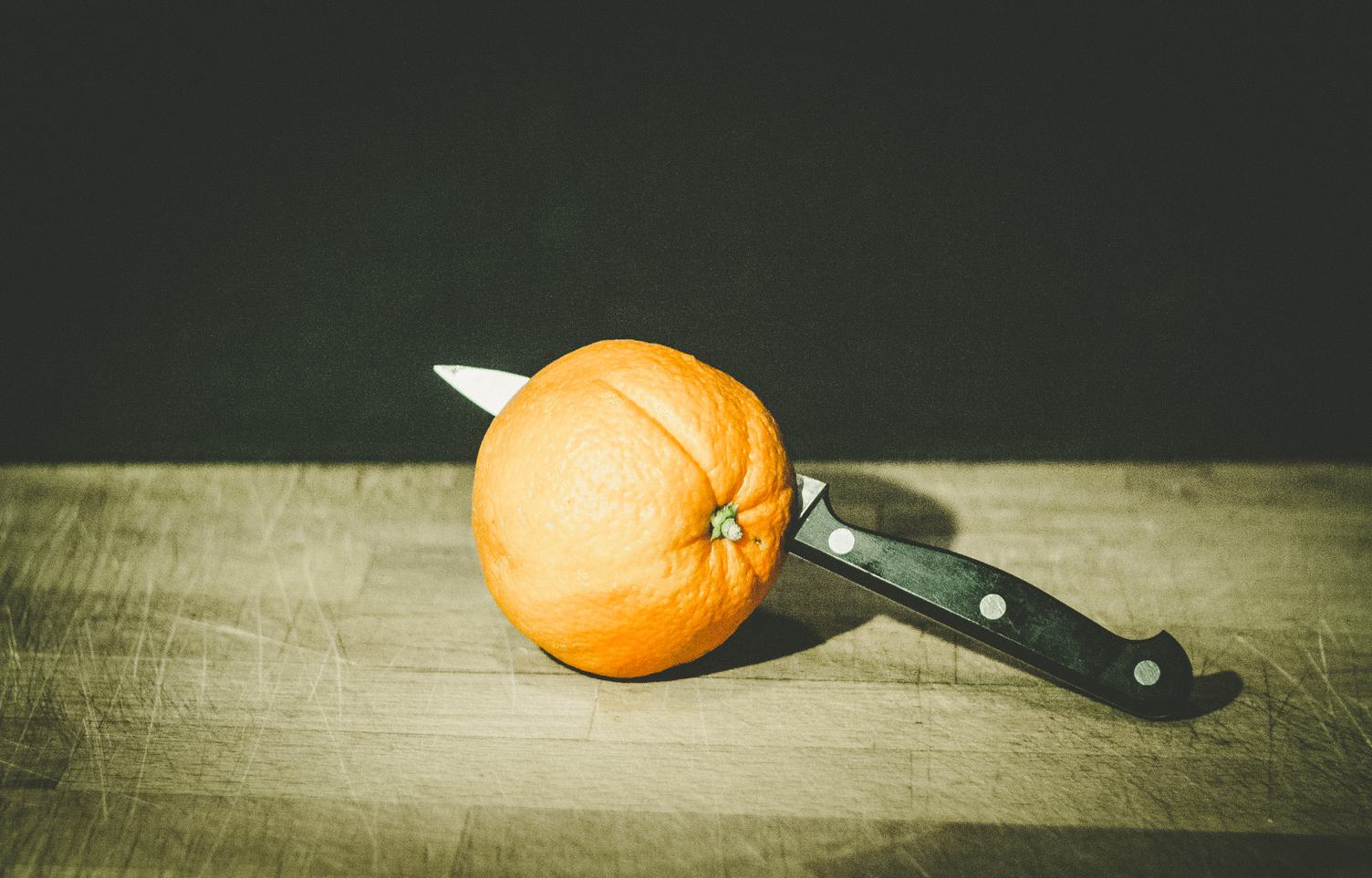 Orange with Knife on Old Cutting Board