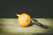 Orange with Knife on Old Cutting Board
