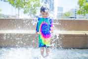 Smiling Boy is Bathed and Splashing in the Fountain