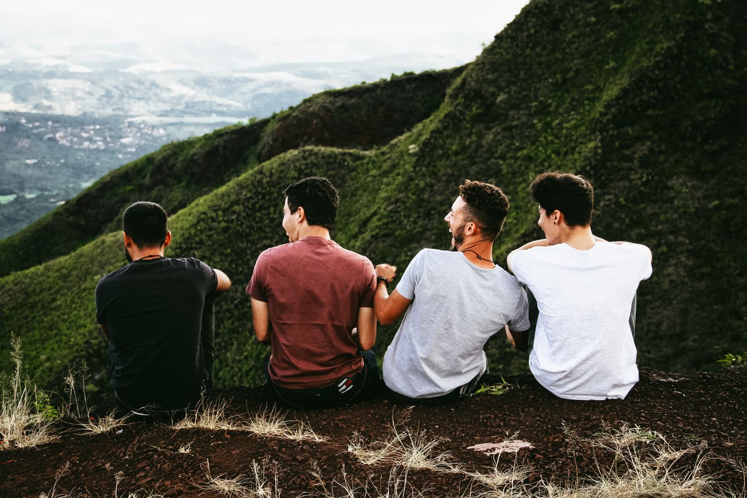 Four Guys Sitting on Cliff and Talking and Laughing