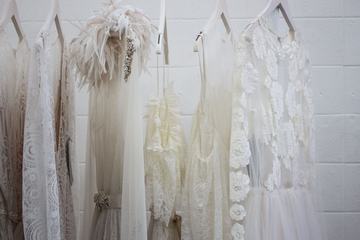 White Elegant Dresses on Hangers against White Wall