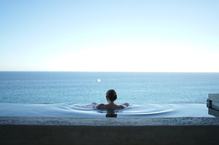 Woman in the Infinity Pool Enjoying the Ocean View