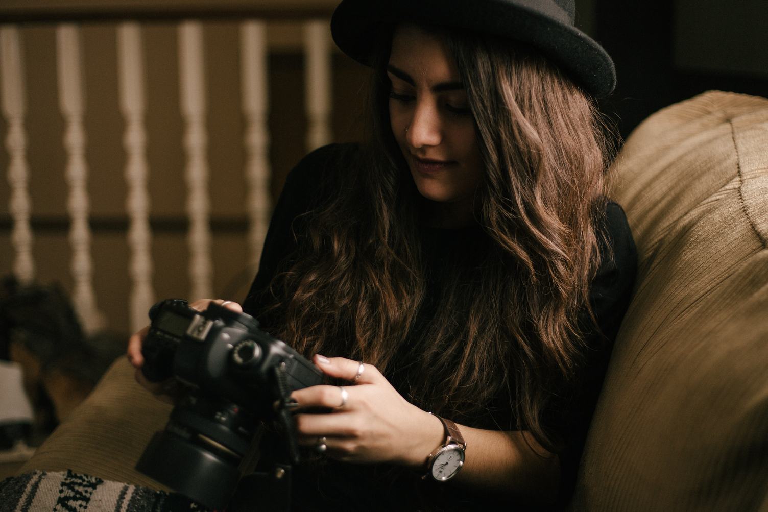 Brunette Check Photos on Camera while Sitting on Sofa