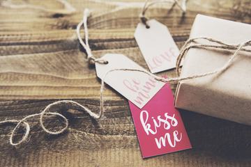 Gift and Labels on Wooden Background